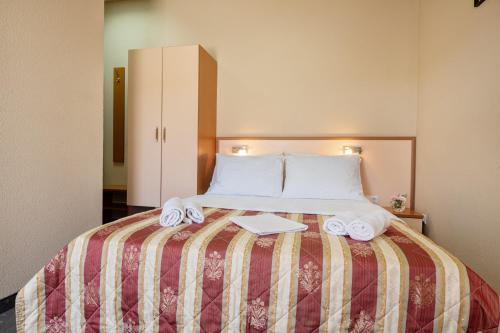 a bed with towels and a book on it at Hotel Luna in Neum