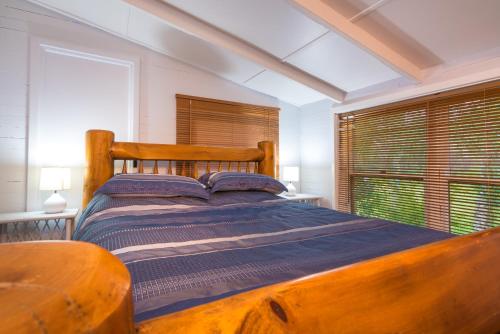 een slaapkamer met een houten bed en een raam bij Chestnut Brae - Chestnut Cottage in Nannup