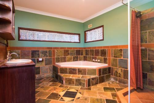 a bathroom with a tub and a sink at Chestnut Brae Farmstay - Chestnut Retreat in Nannup