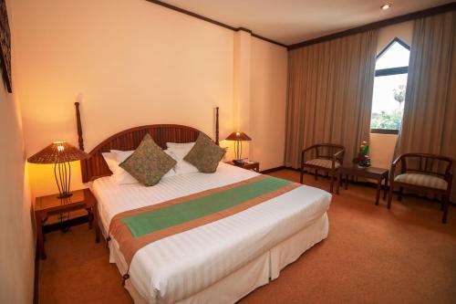 a bedroom with a large bed in a hotel room at LAOTEL VIENTIANE in Vientiane
