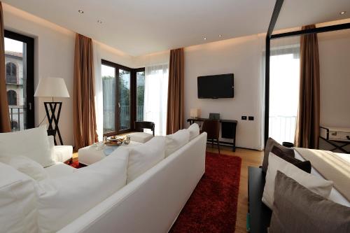 a living room with white furniture and a flat screen tv at Principe Forte Dei Marmi - Resort & Spa in Forte dei Marmi