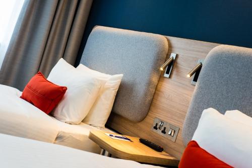 a hotel room with a bed with red and white pillows at Holiday Inn Express Strathclyde Park M74, Jct 5 by IHG in Motherwell