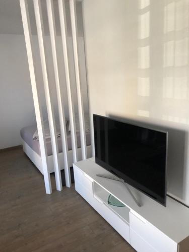 a living room with a flat screen tv and a crib at Bürgemeister Apartment in Augsburg