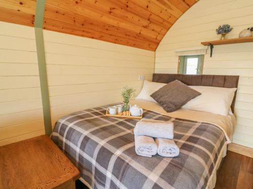 a bed in a cabin with two towels on it at Valley View in Rhayader