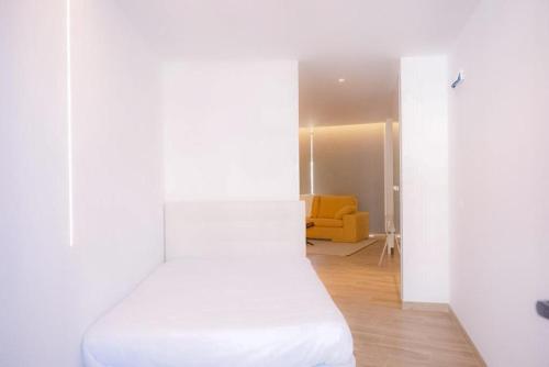 アヴェイロにあるLoft CMJMの白い部屋(ベッド1台、黄色のソファ付)