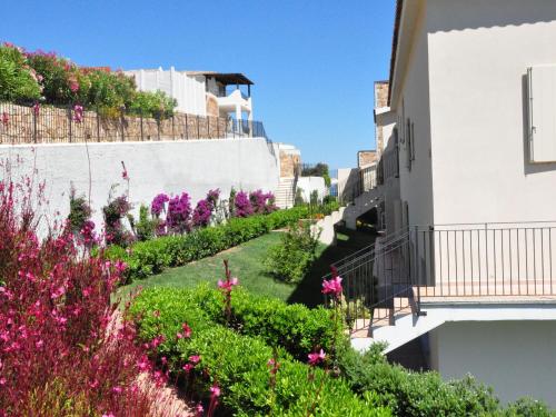 Baraccamentiにあるelegant apartment near the beach of Baja Sardiniaの花の咲く建物の脇の庭