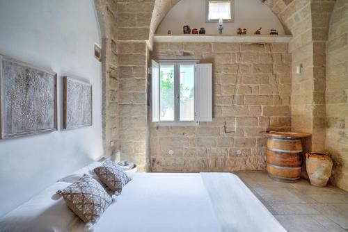 a bedroom with a white bed and a window at Li Perrini Boutique B&B in Acquarica