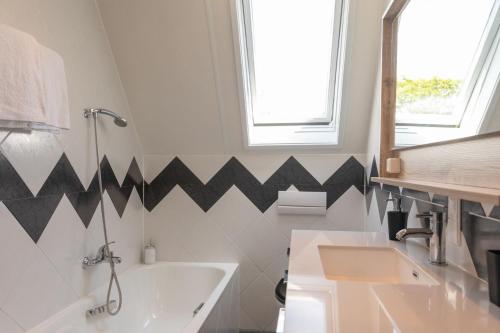 a bathroom with black and white arrows on the wall at Hotel-Restaurant Loodsmans Welvaren in Den Hoorn