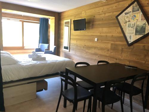 a bedroom with a bed and a table and chairs at VVF Les Écrins Saint-Léger-les-Mélèzes in Saint-Léger-les-Mélèzes