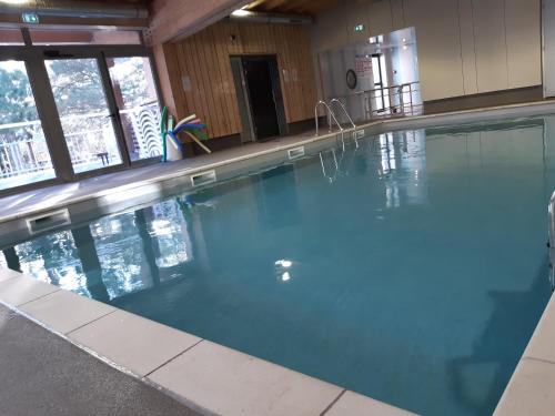 uma grande piscina com água azul num edifício em VVF Les Écrins Saint-Léger-les-Mélèzes em Saint-Léger-les-Mélèzes