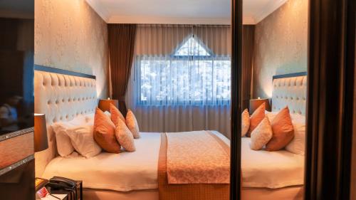a bedroom with a bed with pillows and a window at LAOTEL VIENTIANE in Vientiane