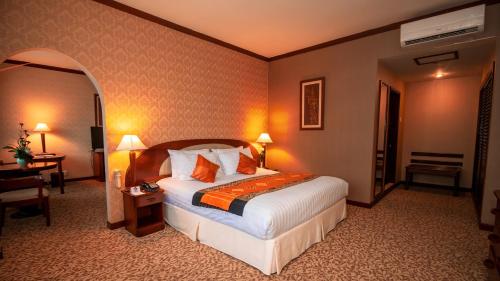 a hotel room with a bed and a desk at LAOTEL VIENTIANE in Vientiane