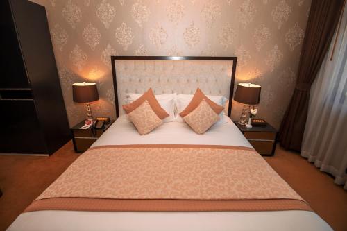 a bedroom with a bed with pillows and two lamps at LAOTEL VIENTIANE in Vientiane