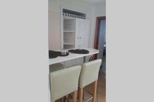 eine Küche mit zwei Waschbecken und zwei Stühlen in der Unterkunft Casa Mammarella in Positano