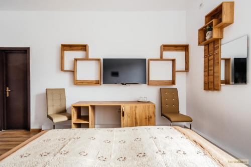 a room with a table and chairs and a tv at Hotel Carpati in Gura Humorului