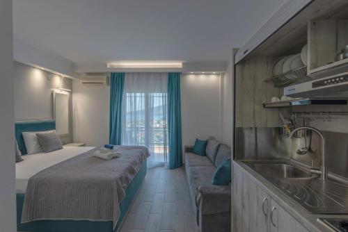 1 dormitorio con cama, sofá y lavamanos en Golden View Studios, en Chrysi Ammoudia