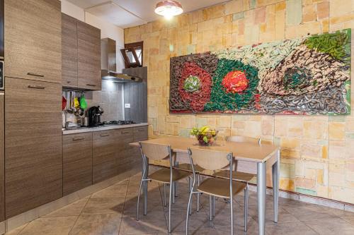 a kitchen with a table and a painting on the wall at B&B IL Cammino in Lanciano