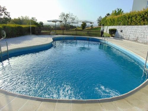a large pool with blue water in a yard at Hospedium Hotel Valles de Gredos Golf in Talayuela