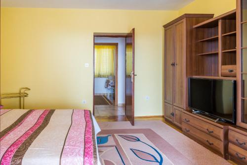 um quarto com uma cama e uma televisão de ecrã plano em Belvedere Apartments em Krk