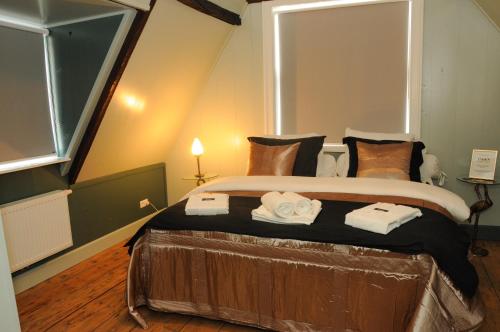 1 dormitorio con 1 cama grande y toallas. en Bed en kerk monumentale 2 slaapkamer woning, en Hoorn