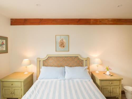 a bedroom with a bed with two night stands and two lamps at Pond View in Fordingbridge