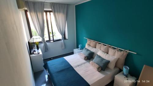 - une chambre avec des murs bleus et un lit avec des oreillers dans l'établissement Luxury Catania, à Catane