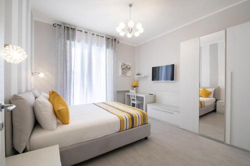 um quarto branco com uma cama e um espelho em Casa La Perla em Sorrento