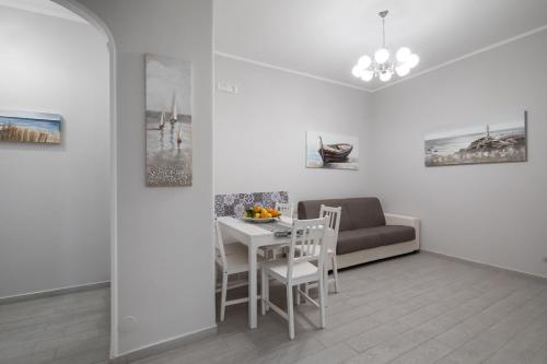 uma sala de estar branca com uma mesa e um sofá em Casa La Perla em Sorrento