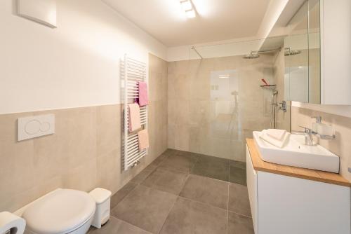 a bathroom with a white toilet and a sink at Haus Piger in Termeno