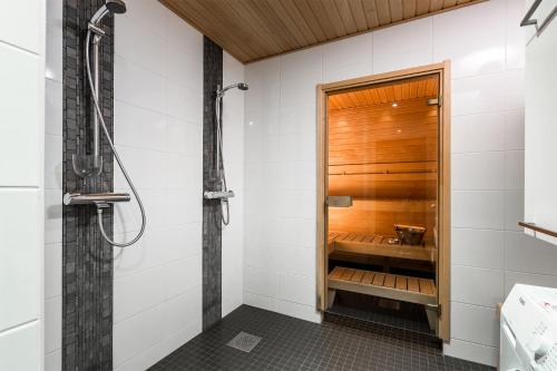 a bathroom with a shower and a wooden shower stall at Imatran Kylpylä Spa Apartments in Imatra