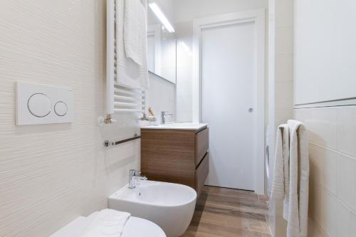 biała łazienka z toaletą i umywalką w obiekcie UR Nest Aposa w Bolonii