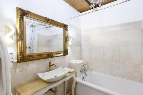 a bathroom with a sink and a tub and a mirror at A castle spirit apartment in Château du Châtelard in Clarens