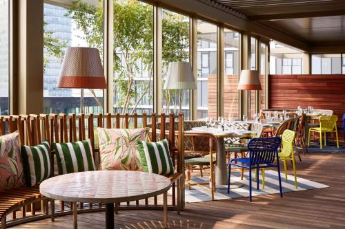 a restaurant with tables and chairs and windows at Mama Shelter Luxembourg in Luxembourg