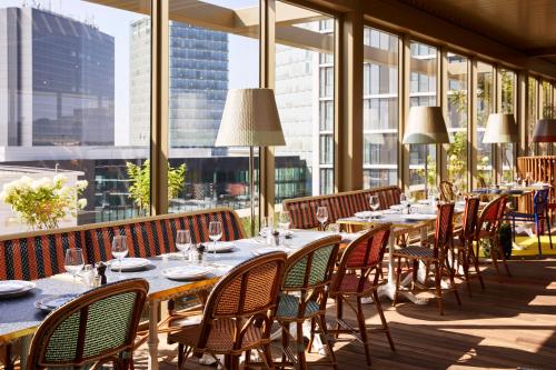 a restaurant with tables and chairs and windows at Mama Shelter Luxembourg in Luxembourg