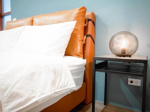 1 cama con almohada y mesa auxiliar con lámpara en Rightday Inn, en Dongshan