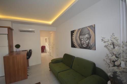 a living room with a green couch and a picture at Camyuva Beach Hotel in Kemer