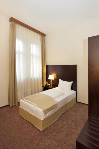 a bedroom with a large bed and a window at Grand Palace Hotel Hannover in Hannover