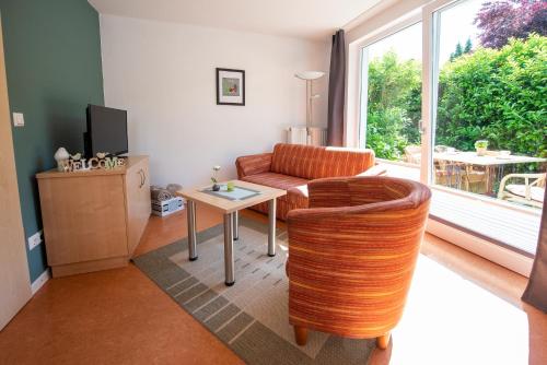 a living room with a couch and a table at De Kanalkieker Apartmenthaus Meier in Berkenthin