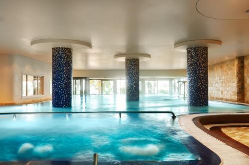 a swimming pool with blue water in a building at Marbella Club Hotel · Golf Resort & Spa in Marbella