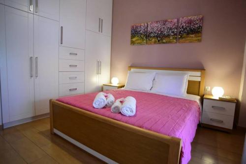 een slaapkamer met een bed met twee handdoeken erop bij Nasia's house in Ágios Rókkos