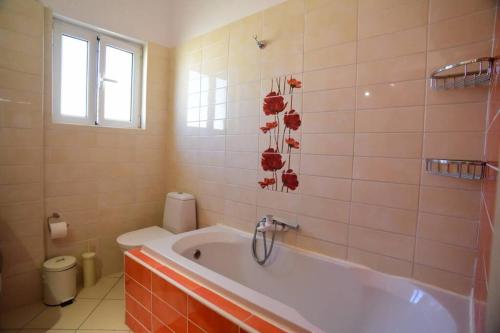 a bathroom with a tub and a toilet at Nasia's house in Agios Rokkos