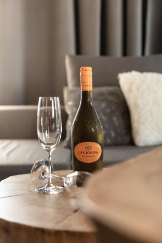 a bottle of wine and a glass on a table at GOING TRIPLE A apartments EAST in Going