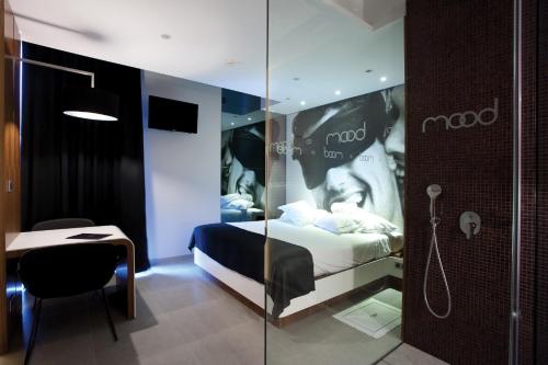 a hotel room with a bed and a glass wall at Mood - Private Suites in Montijo