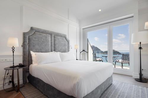 a bedroom with a large bed and a large window at Hotel Boutique Villa Favorita in San Sebastián