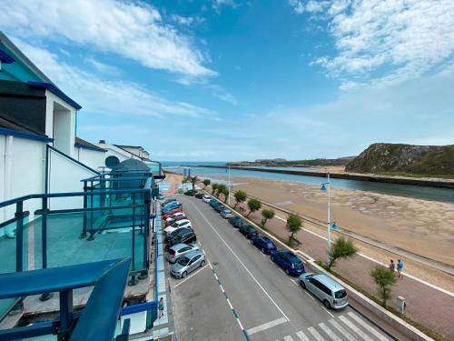 a balcony view of a parking lot and a beach at Hotel Soraya in Suances
