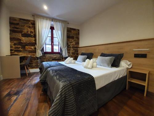 a bedroom with a large bed and a window at Albergue Casa Cuartel in Fonsagrada