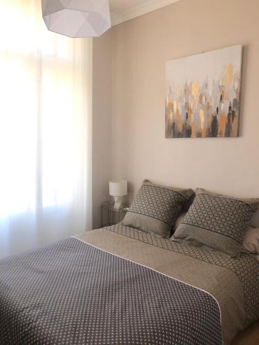 a bedroom with two beds and a painting on the wall at Un petit coin de Bastide in Carcassonne