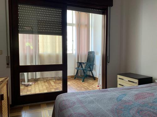 um quarto com uma porta aberta para um quarto com uma cadeira em albu centro em Albufeira