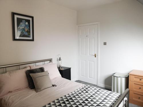 sypialnia z łóżkiem z czarno-białą podłogą wyłożoną szachownicą w obiekcie Switchback Stays Marina Apartments w Cardiff
