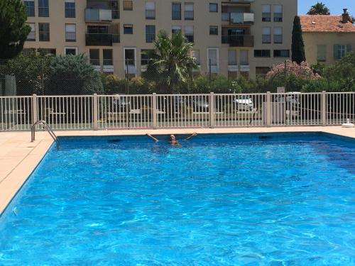 une personne se baignant dans une piscine dans l'établissement T1 résidence privée bien situé,piscine,tennis,parking, à Hyères
